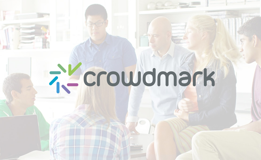 Crowdmark logo overlaying a photo of a small group of people collaborating in an office